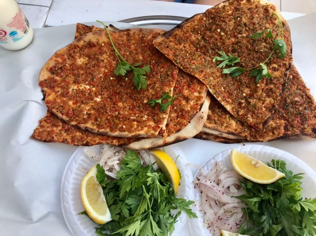 İki dilim közde lahmacun, soğan-maydanoz salatası ve limon